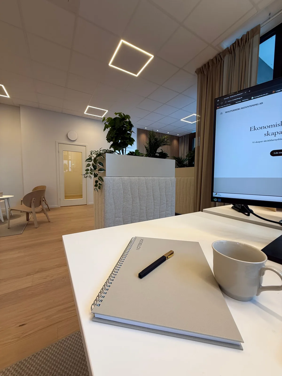 Skrivbord med anteckningsbok och kaffekopp på kontoret